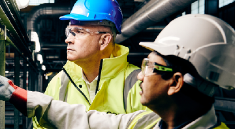 Men in high vis jackets and helmets working together
